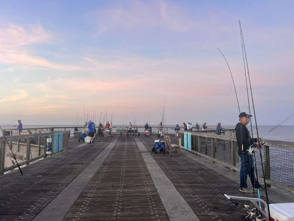 Fisherman on Navarre Beach Pier at sunrise in Florida. 
